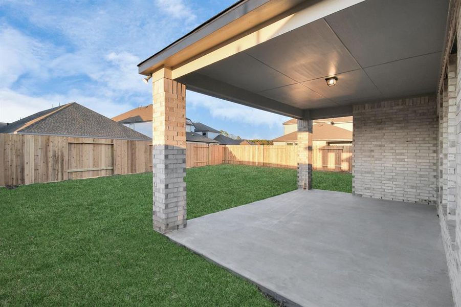 Experience outdoor living at its finest on this expansive covered patio, thoughtfully designed for BBQs and delightful outdoor dining. Sample photo of completed home. Actual colors and selections will vary.