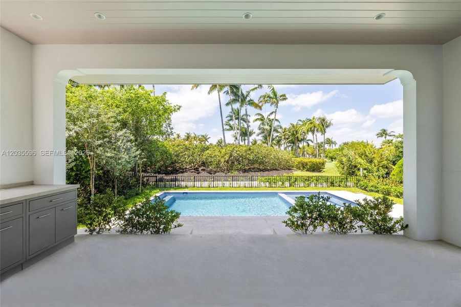 Outside living room with full kitchen overlooks pool Outside living room with full kitchen overlooks pool