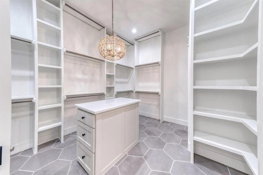 Spacious closet with an inviting chandelier and light tile patterned flooring