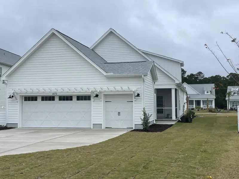 Front exterior of a new home in The Sanctuary at Sunset Beach, Sunset Beach, NC, highlighting curb appeal (Image 1).