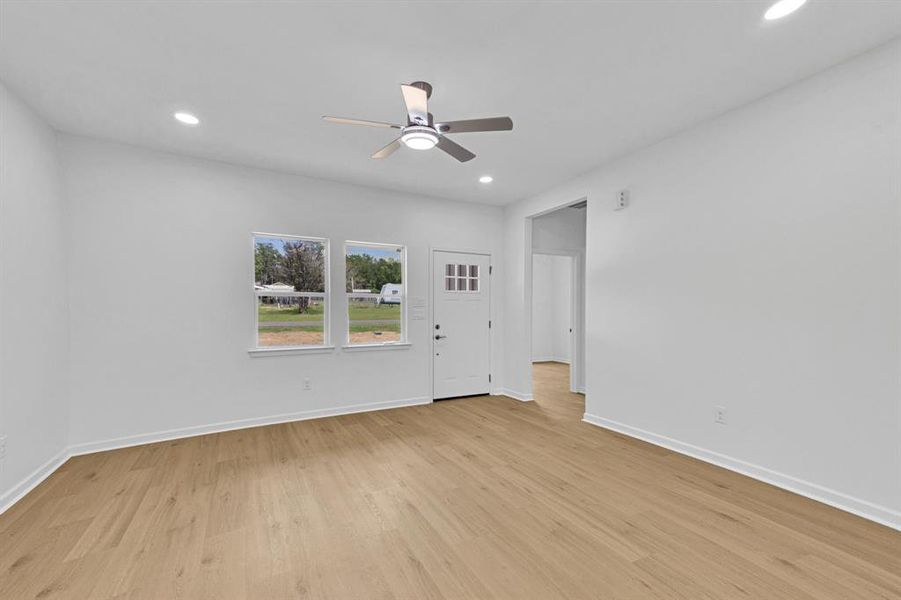 Empty room featuring recessed lighting, light wood-style flooring, and ceiling fan Empty room featuring recessed lighting, light wood-style flooring, and ceiling fan