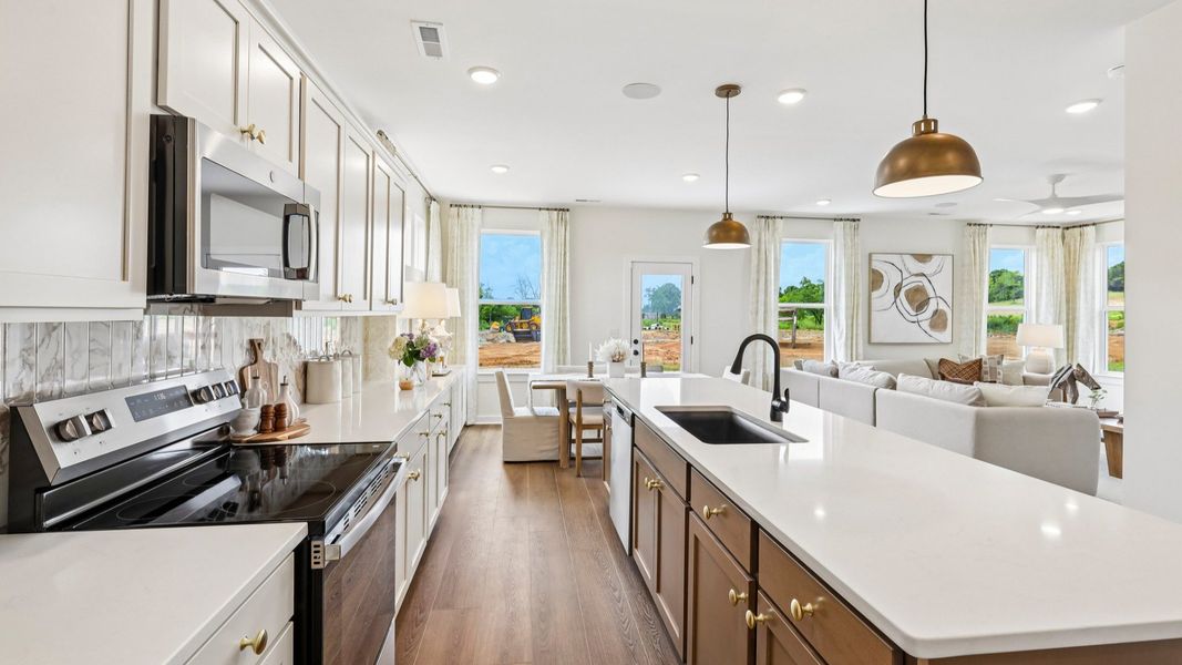 Kitchen with tile backsplash, pendant lighting, and quartz countertops Kitchen with tile backsplash, pendant lighting, and quartz countertops