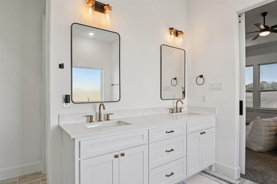 Bathroom featuring double vanity, ceiling fan, and light wood-type flooring Bathroom featuring double vanity, ceiling fan, and light wood-type flooring