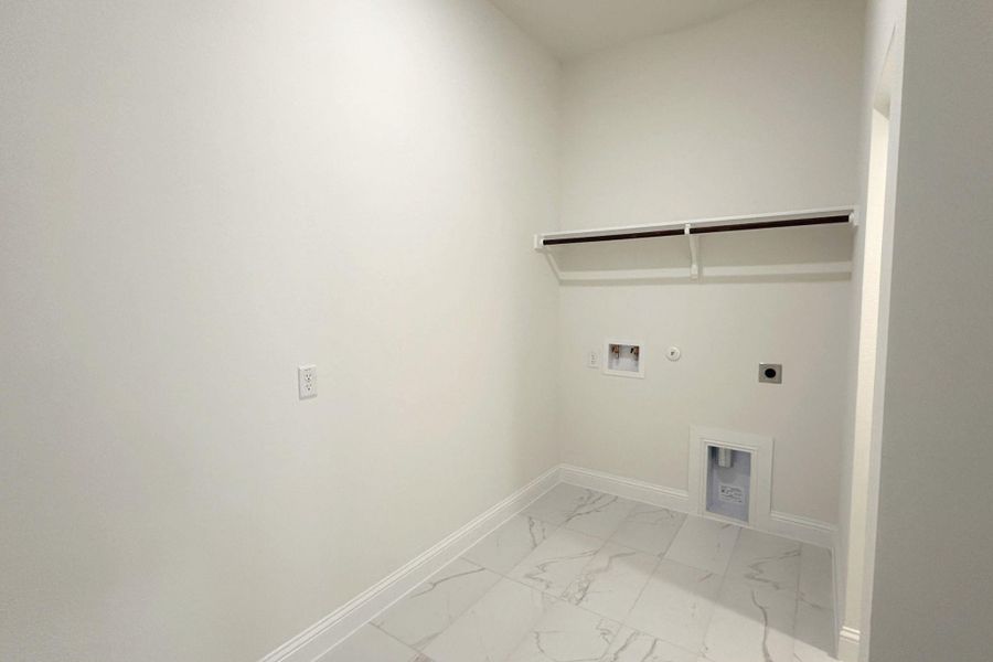 A dedicated utility space with a hanging rod provides convenient laundry solutions.
