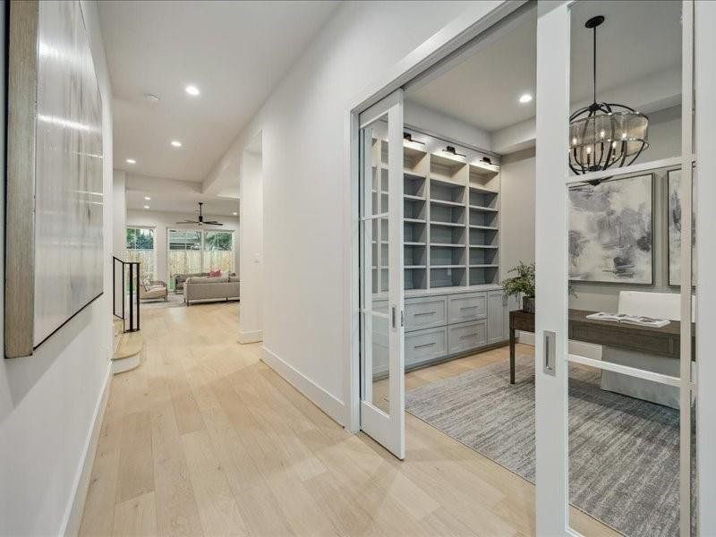 Study off the entrance of the home with built-in shelving, cabinets and drawers.
