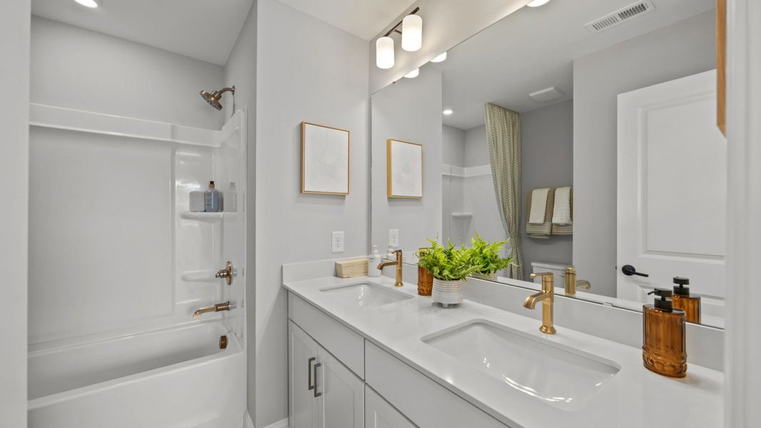 The Rochester Plan by DRB homes bathroom in solid white with gold fixtures in Charlotte, NC.