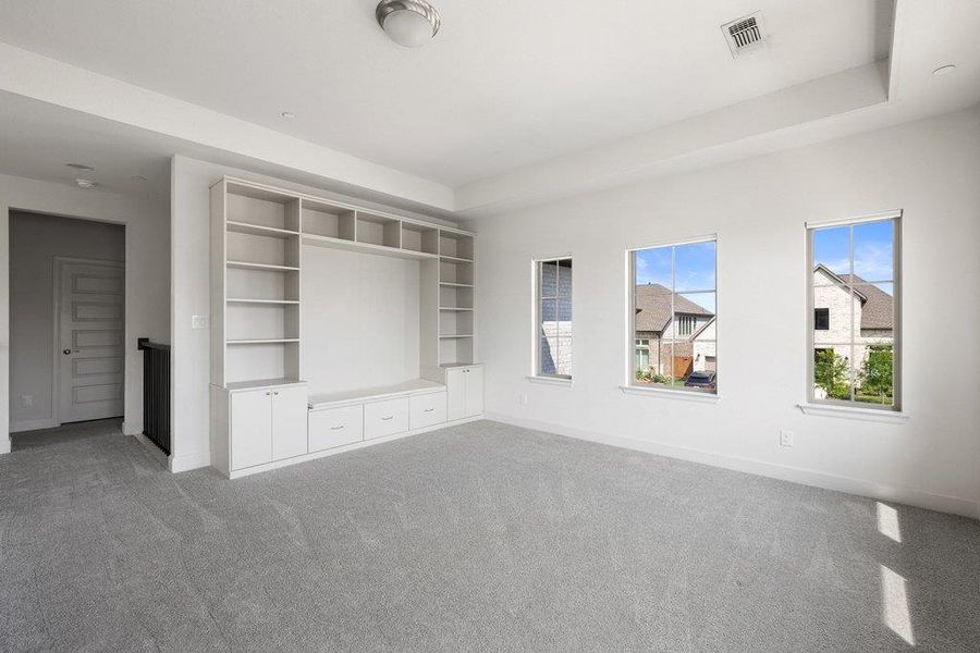 A well-lit upper-level living space offers a built-in media center and ample natural illumination.