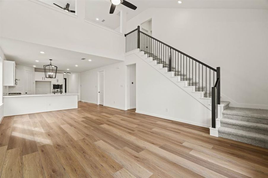 Beautiful staircase in rear of home plateauing at the oversized game room.