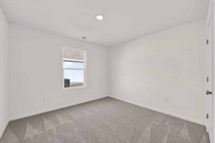 A room with a window and a carpet.