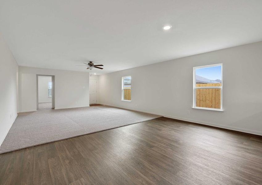 The Medina model's formal dining room (front) and living room (back). Ceiling fan, recessed lighting and two windows