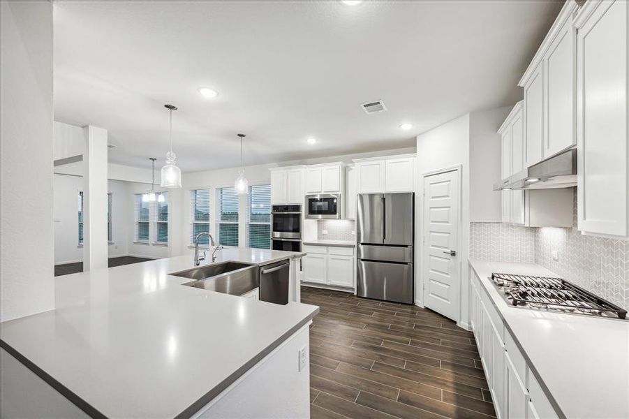 Enjoy this inviting view of the kitchen featuring a charming farmhouse sink, perfectly positioned to overlook the family and breakfast room. The open design creates a seamless flow between spaces, while the abundance of natural light pours in, enhancing the warmth and brightness of the area. This kitchen is not only functional but also a welcoming hub for family gatherings and socializing.