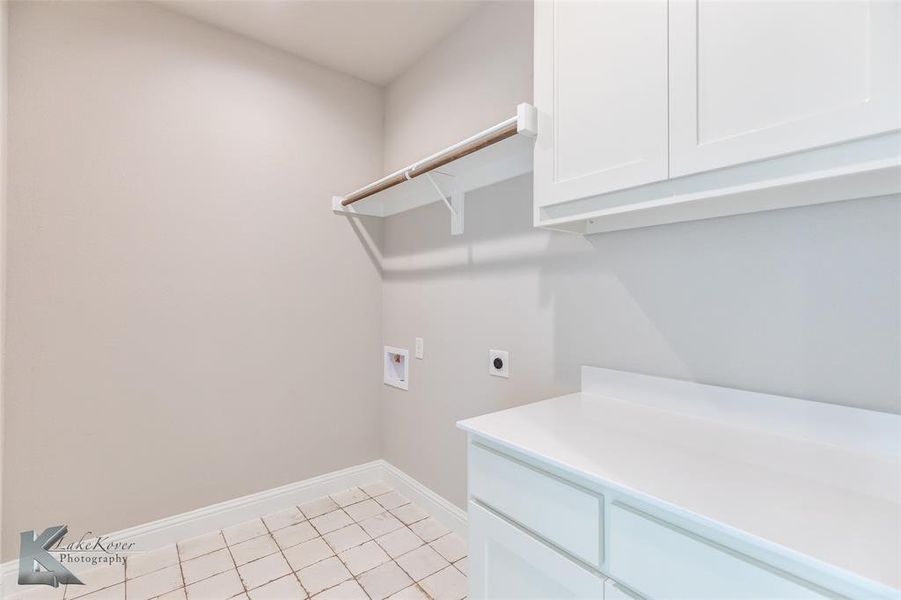 Laundry room featuring electric dryer hookup, ceramic tile floors, cabinet space, and washer hookup