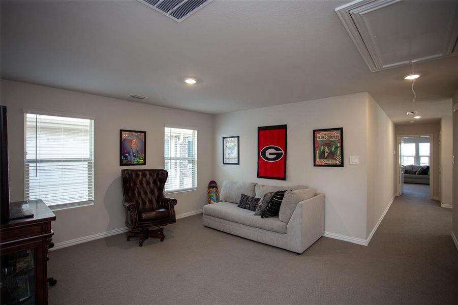 Carpeted living room with attic access, recessed lighting, baseboards, and visible vents