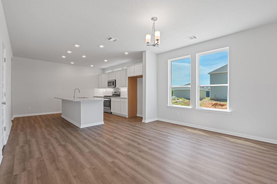Kitchen with stainless steel appliances, light wood finished floors, a chandelier, recessed lighting, and white cabinetry Kitchen with stainless steel appliances, light wood finished floors, a chandelier, recessed lighting, and white cabinetry