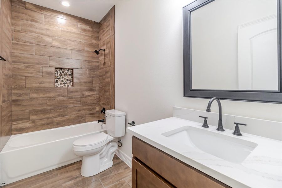 The second full bath repeats the quartz, wood cabinetry, matte-black fixtures, and tile surround, so it doesn’t read like an afterthought. The second full bath repeats the quartz, wood cabinetry, matte-black fixtures, and tile surround, so it doesn’t read like an afterthought.