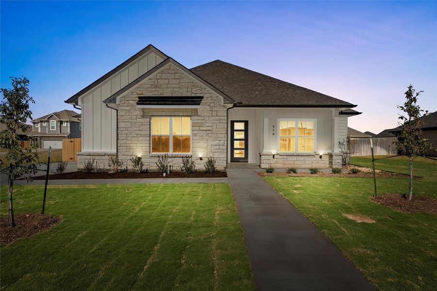 View of front facade featuring board and batten siding, stone siding, and a shingled roof