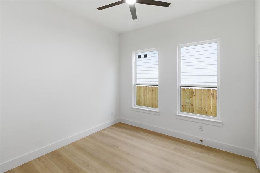 Empty room with light wood-type flooring and a ceiling fan