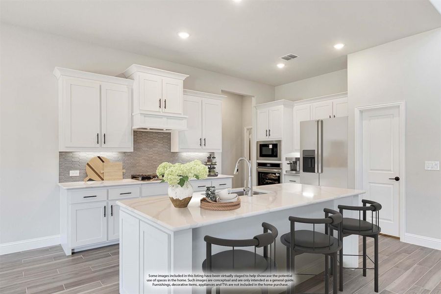 Kitchen with white cabinets, large center island, stainless steel appliances, and gray tile backsplash Kitchen with white cabinets, large center island, stainless steel appliances, and gray tile backsplash