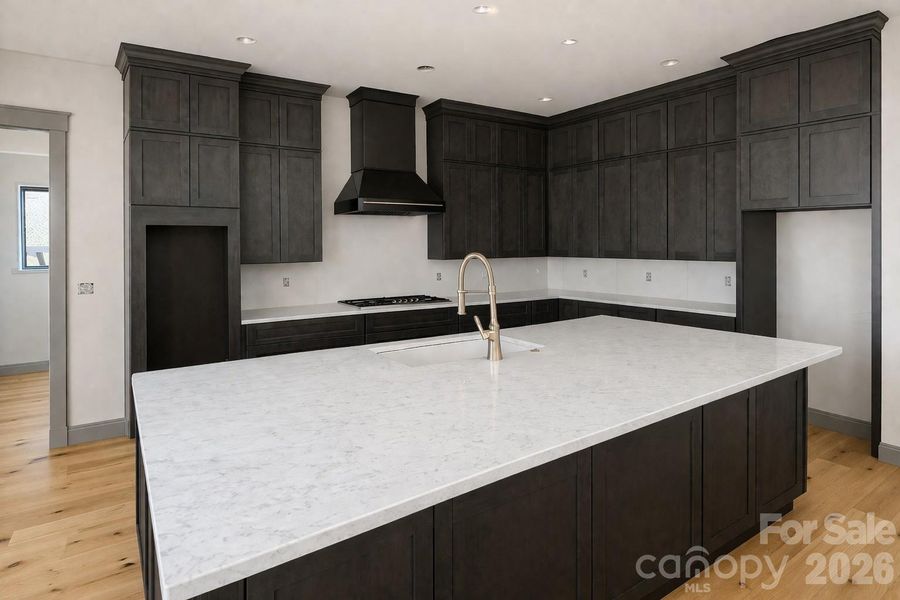 Gourmet kitchen featuring quartzite countertops, premium stainless steel appliances and oversized island.