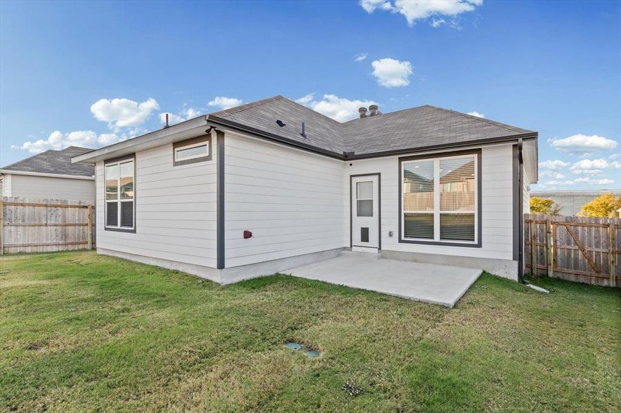 Rear view of property with a fenced backyard, a patio area, and a shingled roof Rear view of property with a fenced backyard, a patio area, and a shingled roof