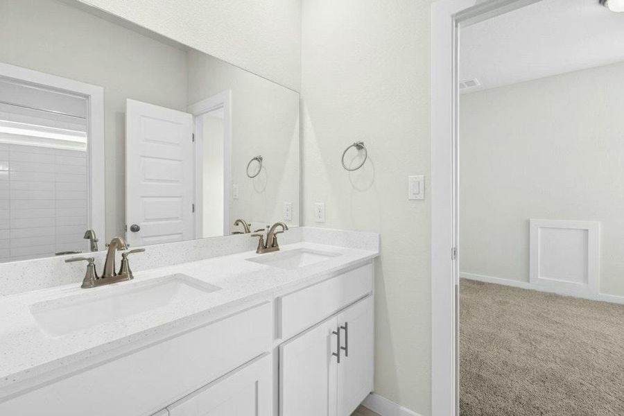 Full bath featuring double vanity and light colored carpet