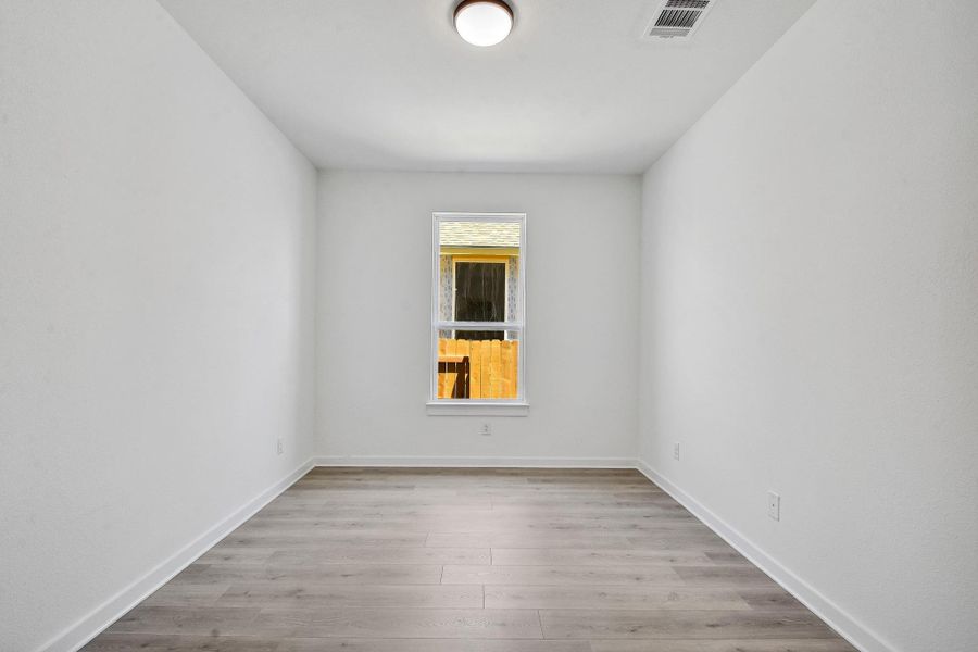 Spare room featuring wood finished floors and baseboards