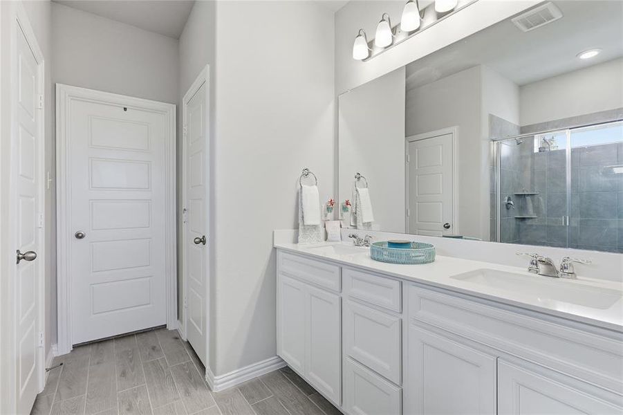 Dual vanity featuring white cabinetry, integrated sinks, and chrome fixtures