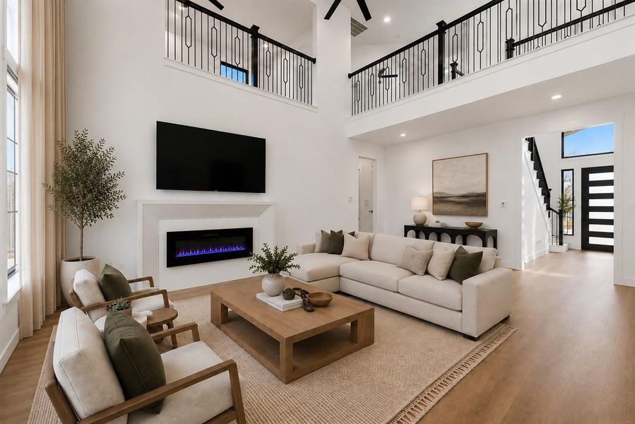The living room showcases a dramatic open to below design, creating an impressive sense of scale. Walls of windows fill the space with natural light!
