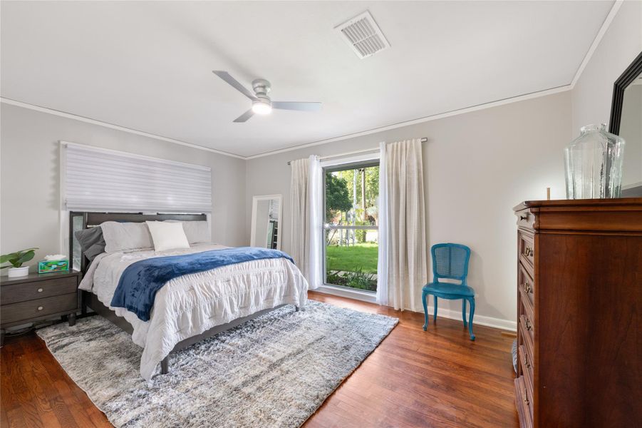 Well-lit sleeping quarters featuring hardwood flooring and a ceiling fan for comfort. Well-lit sleeping quarters featuring hardwood flooring and a ceiling fan for comfort.