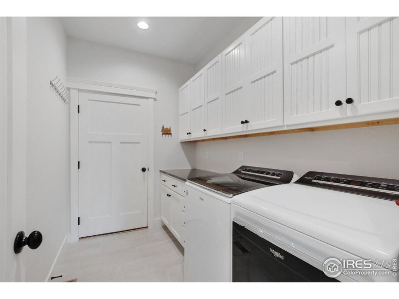 The mudroom/laundry room has a folding table and lots of useful cabinets