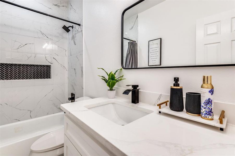Bathroom with vanity and a combined bath / shower with marble appearance