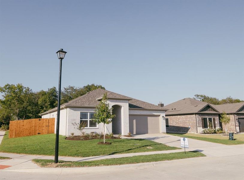 View of front of house with a garage and a front lawn