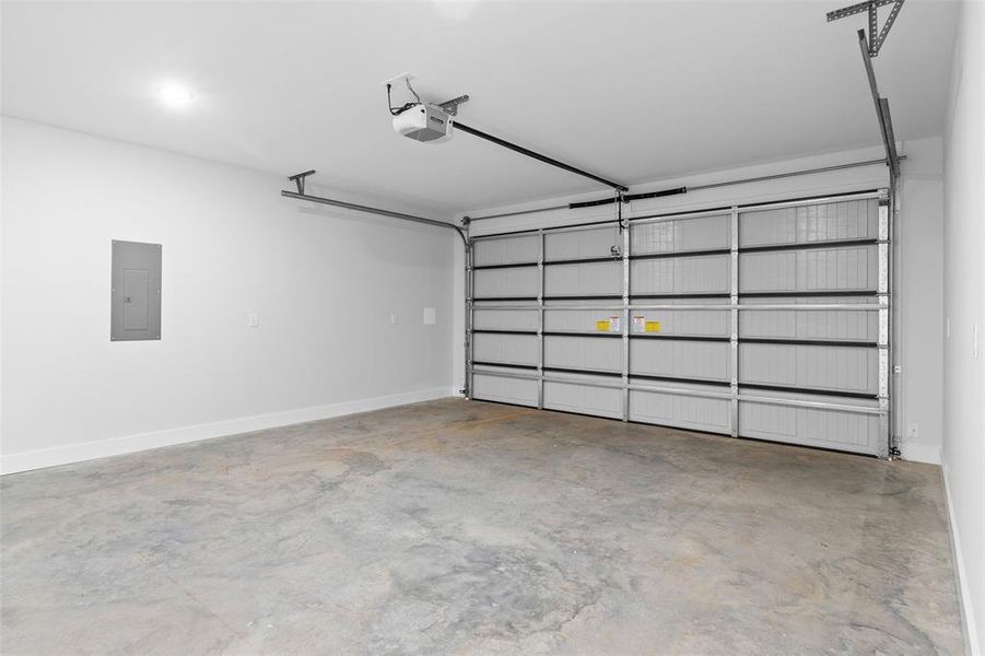 Garage featuring electric panel and a garage door opener