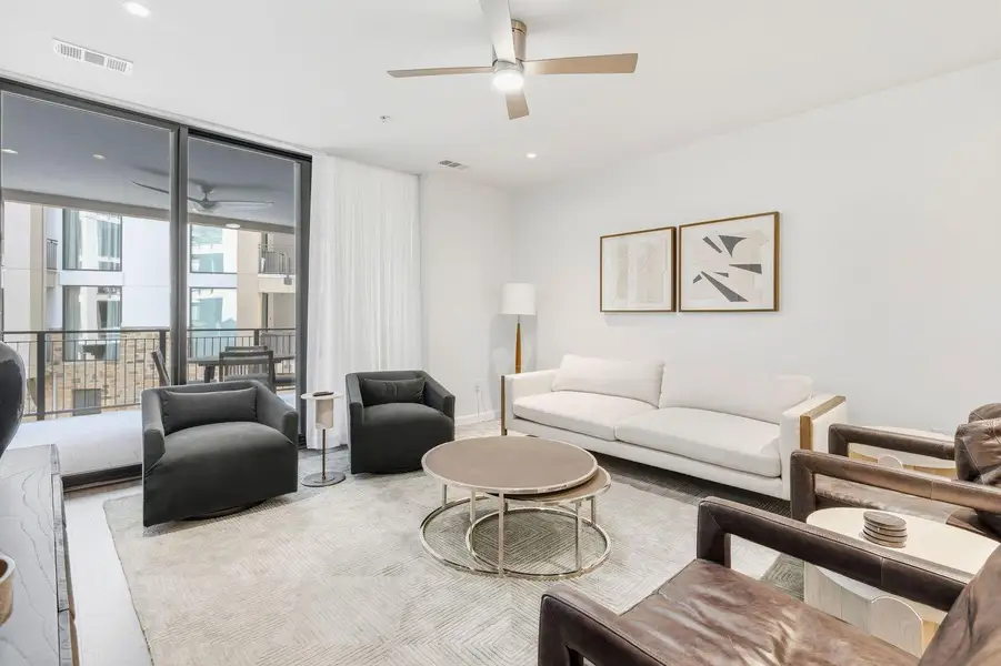 Living room featuring expansive windows, a ceiling fan, and recessed lighting