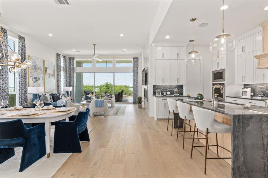 Kitchen with pendant lighting, dark stone counters, backsplash, recessed lighting, and open floor plan Kitchen with pendant lighting, dark stone counters, backsplash, recessed lighting, and open floor plan