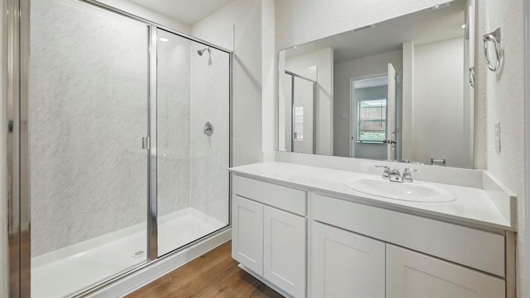 Bathroom featuring a single vanity with white cabinetry and an undermount sink