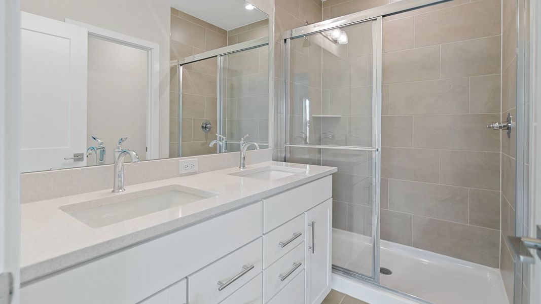 The Atlantic’s owner’s bath includes dual sinks, a spacious vanity, and a tiled walk-in shower with modern glass enclosure. The Atlantic’s owner’s bath includes dual sinks, a spacious vanity, and a tiled walk-in shower with modern glass enclosure.