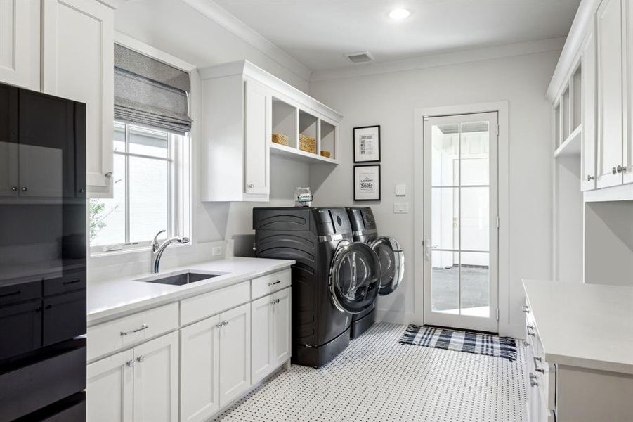 Clothes washing area with cabinet space, visible vents, independent washer and dryer, crown molding, and a sink Clothes washing area with cabinet space, visible vents, independent washer and dryer, crown molding, and a sink