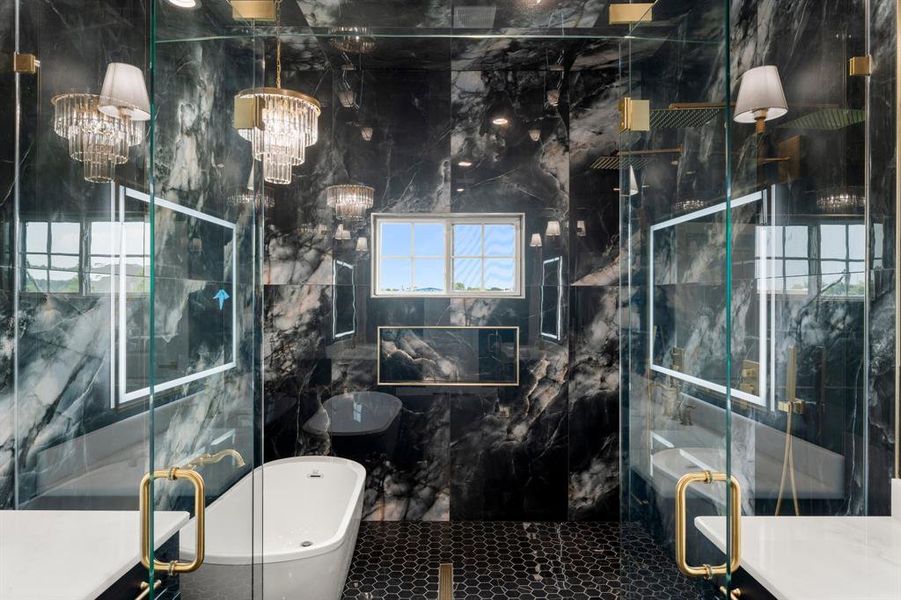 Full bathroom featuring vanity, a freestanding tub, a marble finish shower, and tile walls