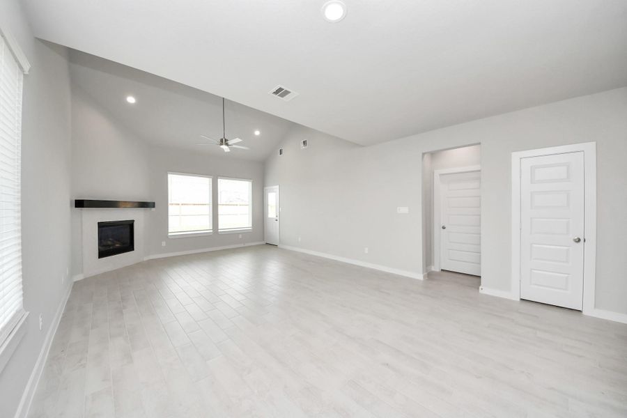 Welcome family and guests to your charming living room! With its high ceilings, recessed lighting, ceiling fan, custom paint, beautiful flooring, and large windows that let in abundant natural light, this room is perfect for gatherings. Sample photo of completed home with similar floor plan. Actual colors and selections may vary.