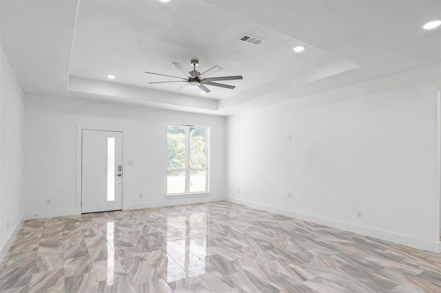 Spare room featuring a tray ceiling and ceiling fan