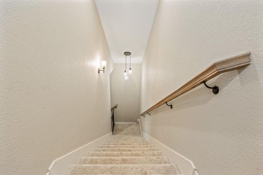Staircase featuring a textured wall Staircase featuring a textured wall