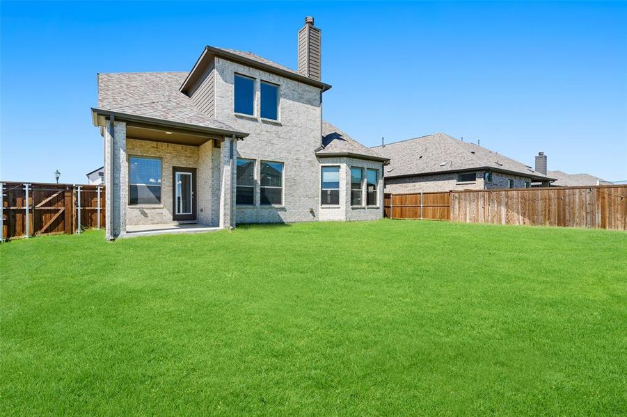 Rear view of house featuring a lawn