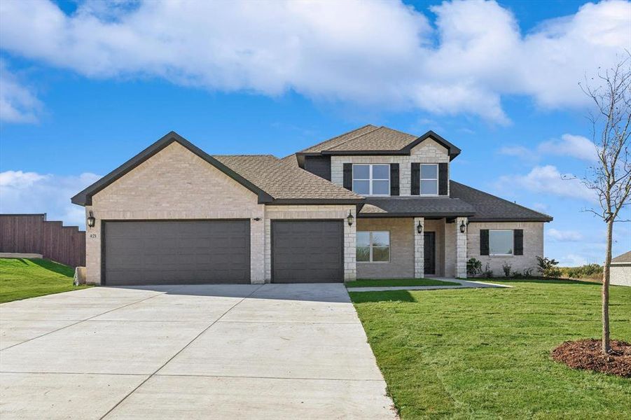 View of front facade with a garage and a front lawn