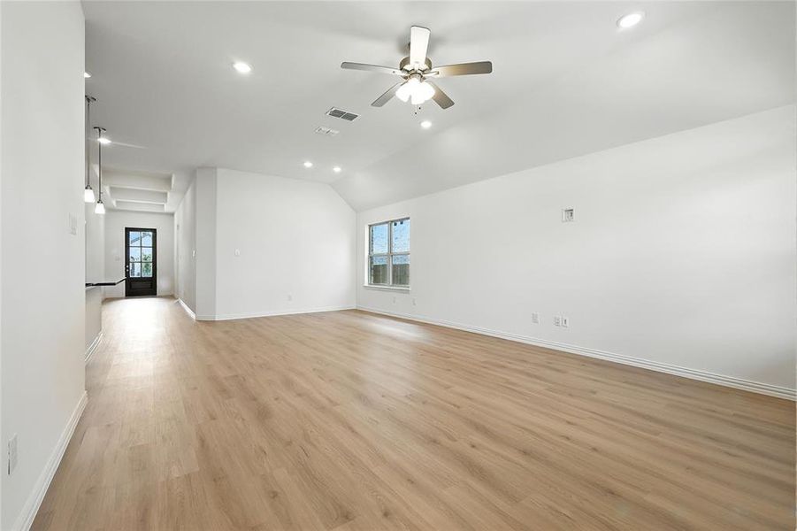 Spare room featuring ceiling fan, recessed lighting, light wood-type flooring, lofted ceiling, and healthy amount of natural light