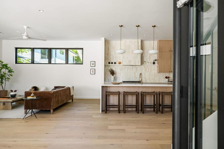 Clean lines and warm wood floors define this open kitchen and living area.