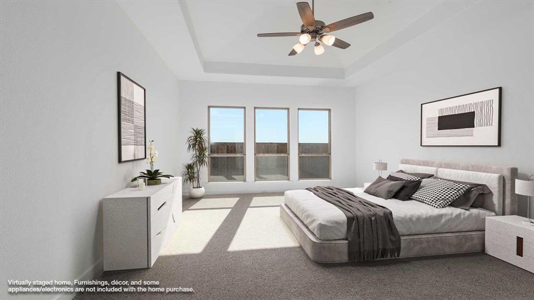 Bedroom with ceiling fan, light carpet, and a tray ceiling