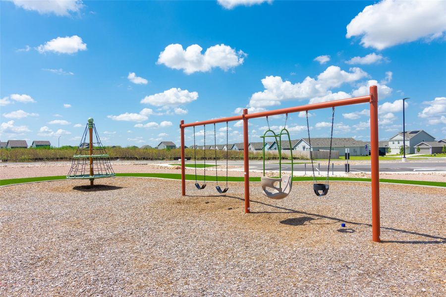 Recreational park area featuring a swing set with multiple swings and a climbing net structure
