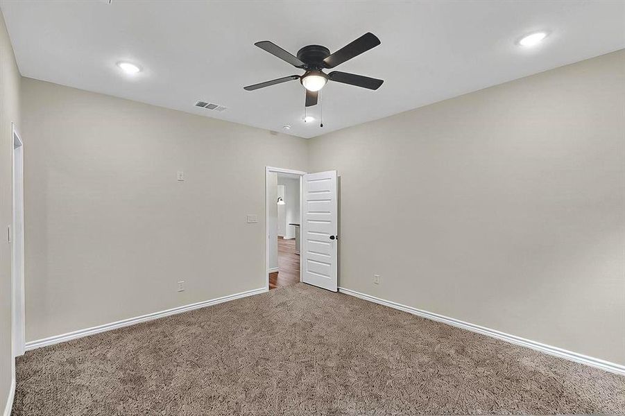 Spare room with carpet flooring, a ceiling fan, baseboards, and visible vents Spare room with carpet flooring, a ceiling fan, baseboards, and visible vents