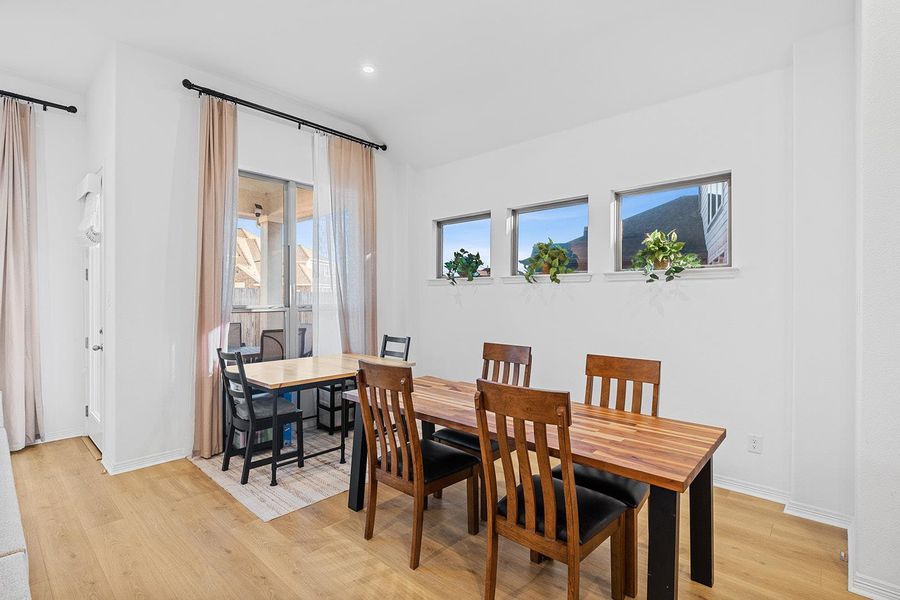 Dining space with light wood-type flooring and recessed lighting
